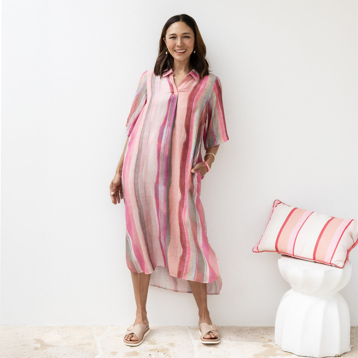 Brunette woman in watercolour pink print travel dress with half sleeves and a collar