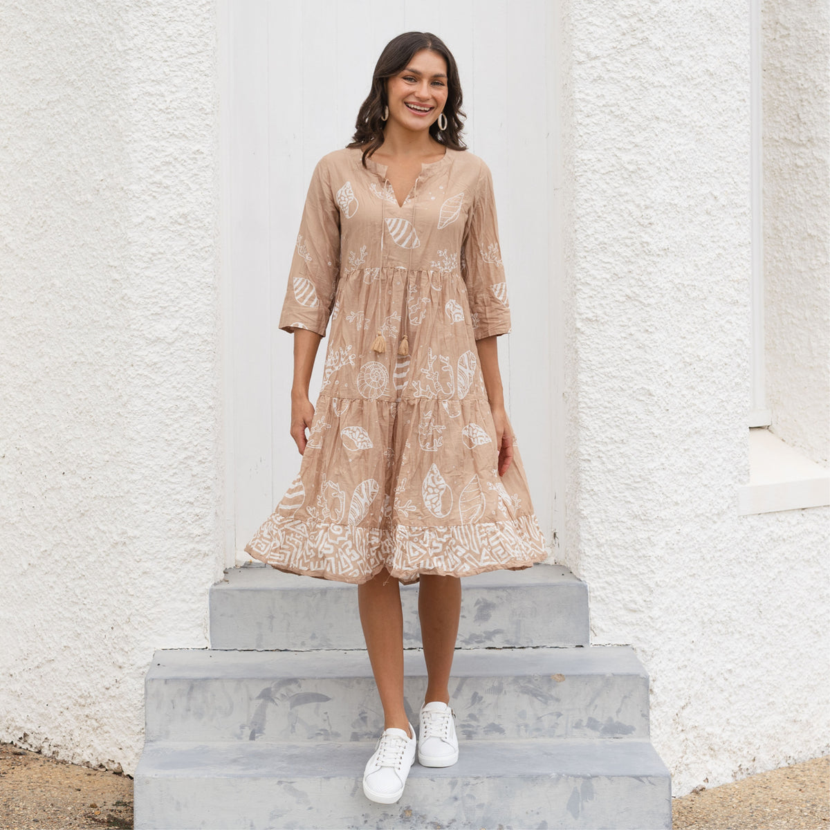 Brunette woman in neutral print no-iron crinkle cotton travel dress 