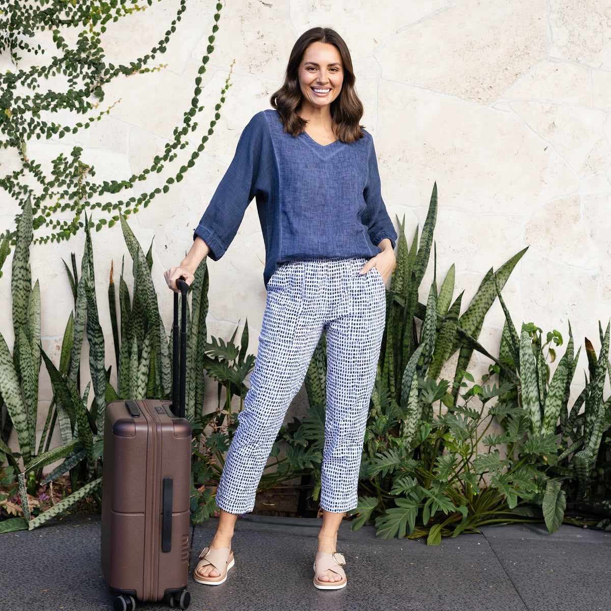 Brunette woman wearing petite friendly cropped Air-Lite pants with pockets.
