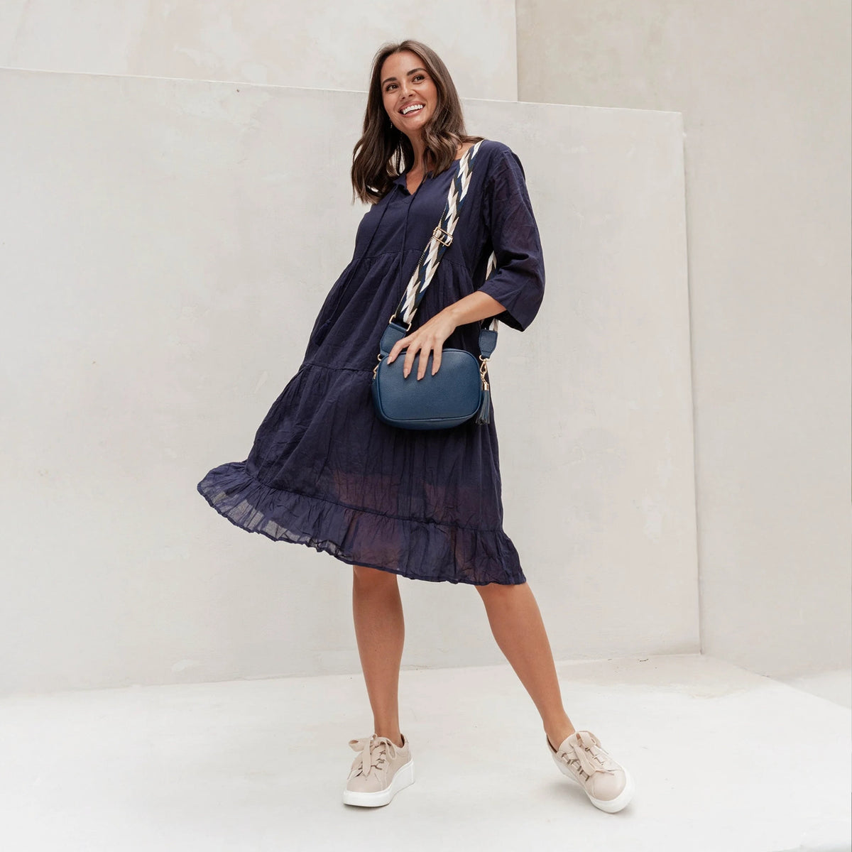 Brunette woman in a navy crinkle no-iron cotton dress with 3/4 sleeves