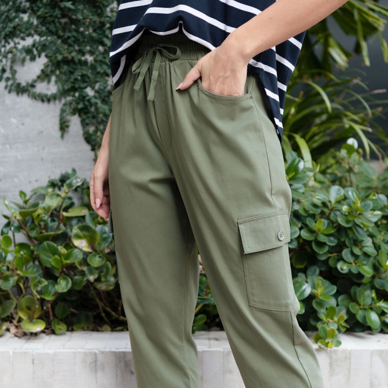 Close up of brunette woman wearing khaki green cargo pants and a black stripe top