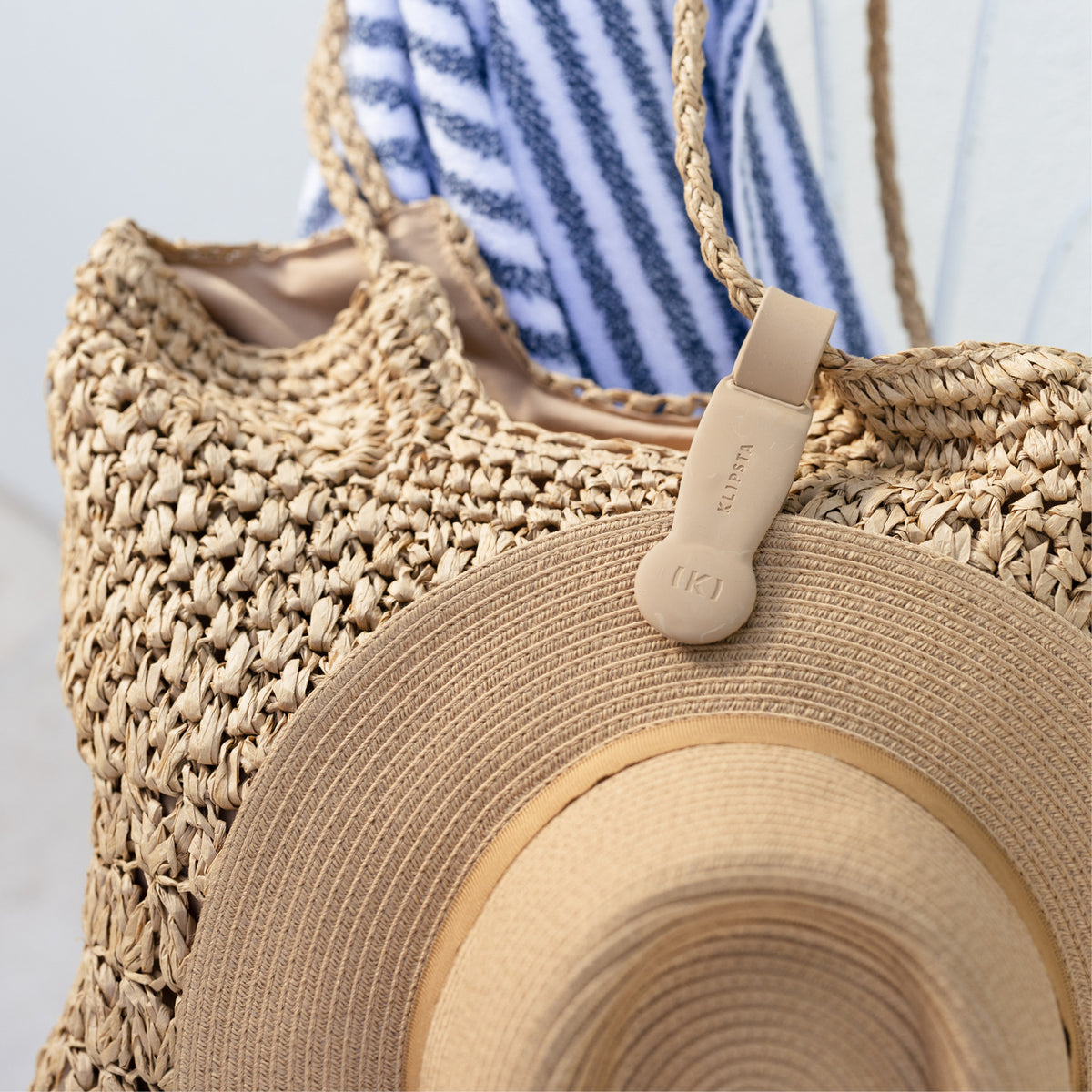 Tan Klipsta hat clip with a straw bag and beige travel hat