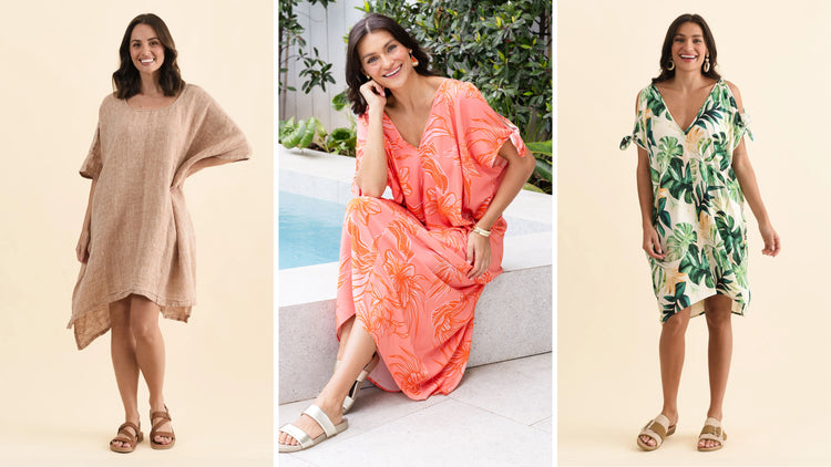 Brunette women in kaftan dresses smile broadly.