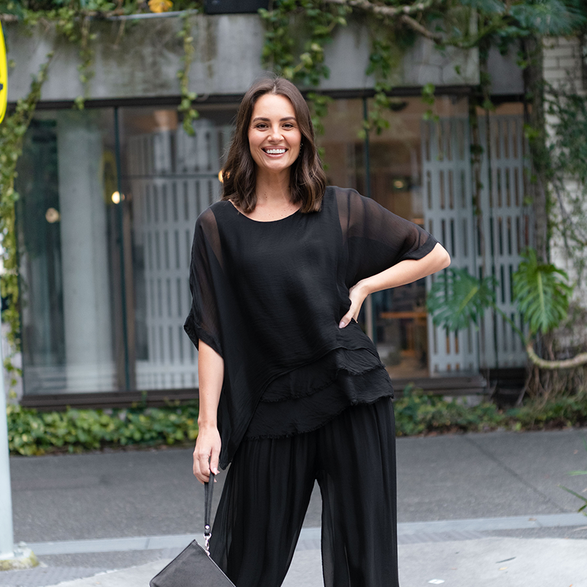 Brunette women wearing a black silk matching set for a date night.